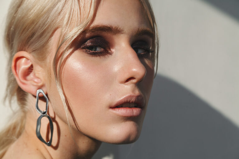 Fashion beauty portrait of young beautiful woman wearing earrings.